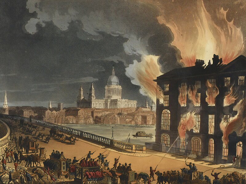 During nighttime, a big three story library is burning on the right hand side of the image.